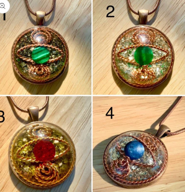 Four circular pendants with embedded stones on a wooden surface