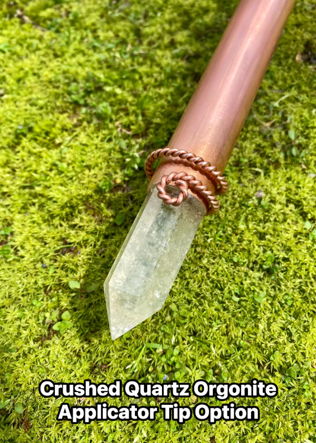 Crystal applicator with copper band on a green moss background