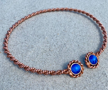 Copper necklace with blue stones on a light gray background