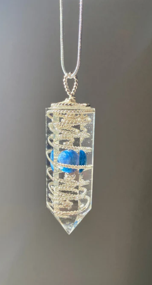 Crystal pendant necklace with blue stone on a gray background