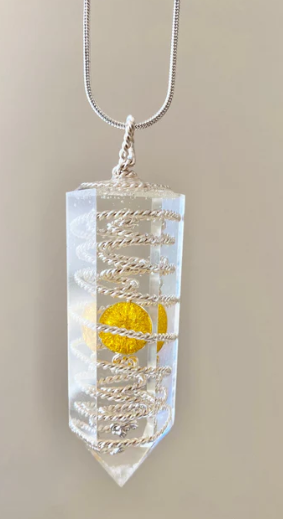 Crystal pendant with a yellow stone on a beige background