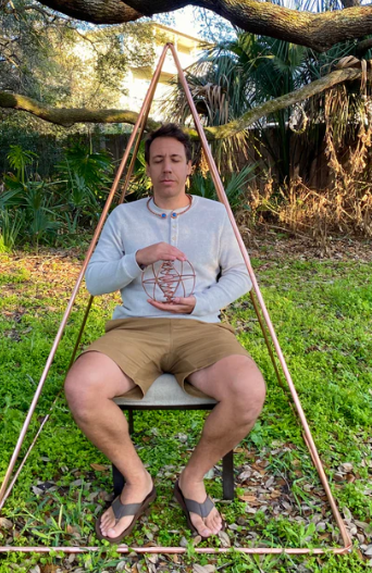 Person sitting on a chair in a natural setting with a geometric frame around them