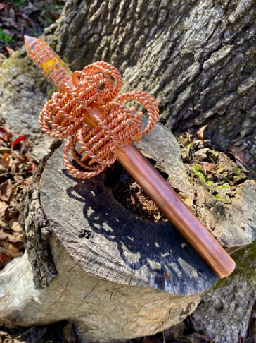 Decorative copper object on a wooden log with a natural background