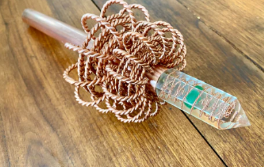  Copper Wand with intricate design and crystal resin on a wooden surface