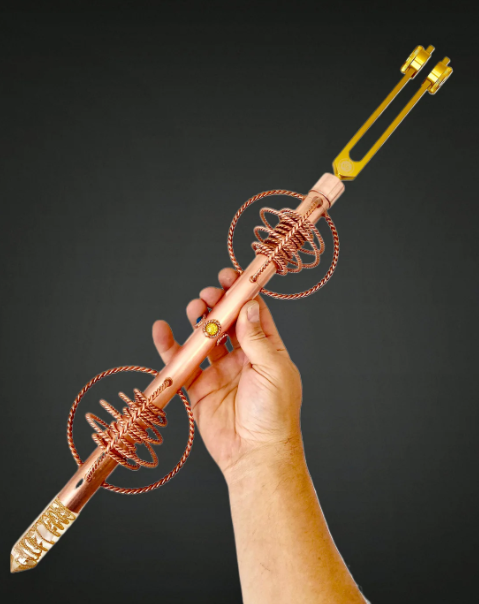 Hand holding a decorative metal tool against a dark background