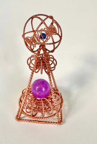 Copper wire sculpture with a purple sphere on a white background