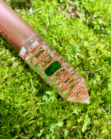 Decorative object with copper detailing on a green moss background