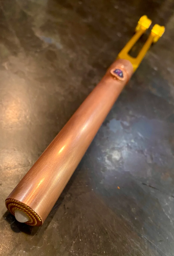Wooden tool with a yellow handle on a metallic surface