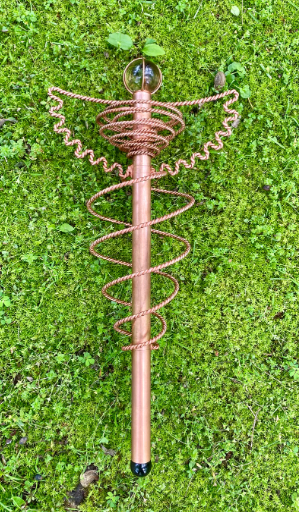 Decorative copper spiral stake on a grassy background