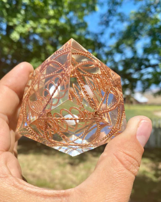 Decorative crystal held in a hand with a blurred natural background